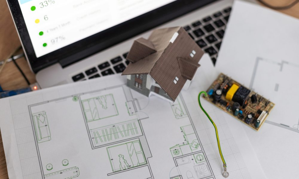 A real estate model and a computer are on the table. High quality photo